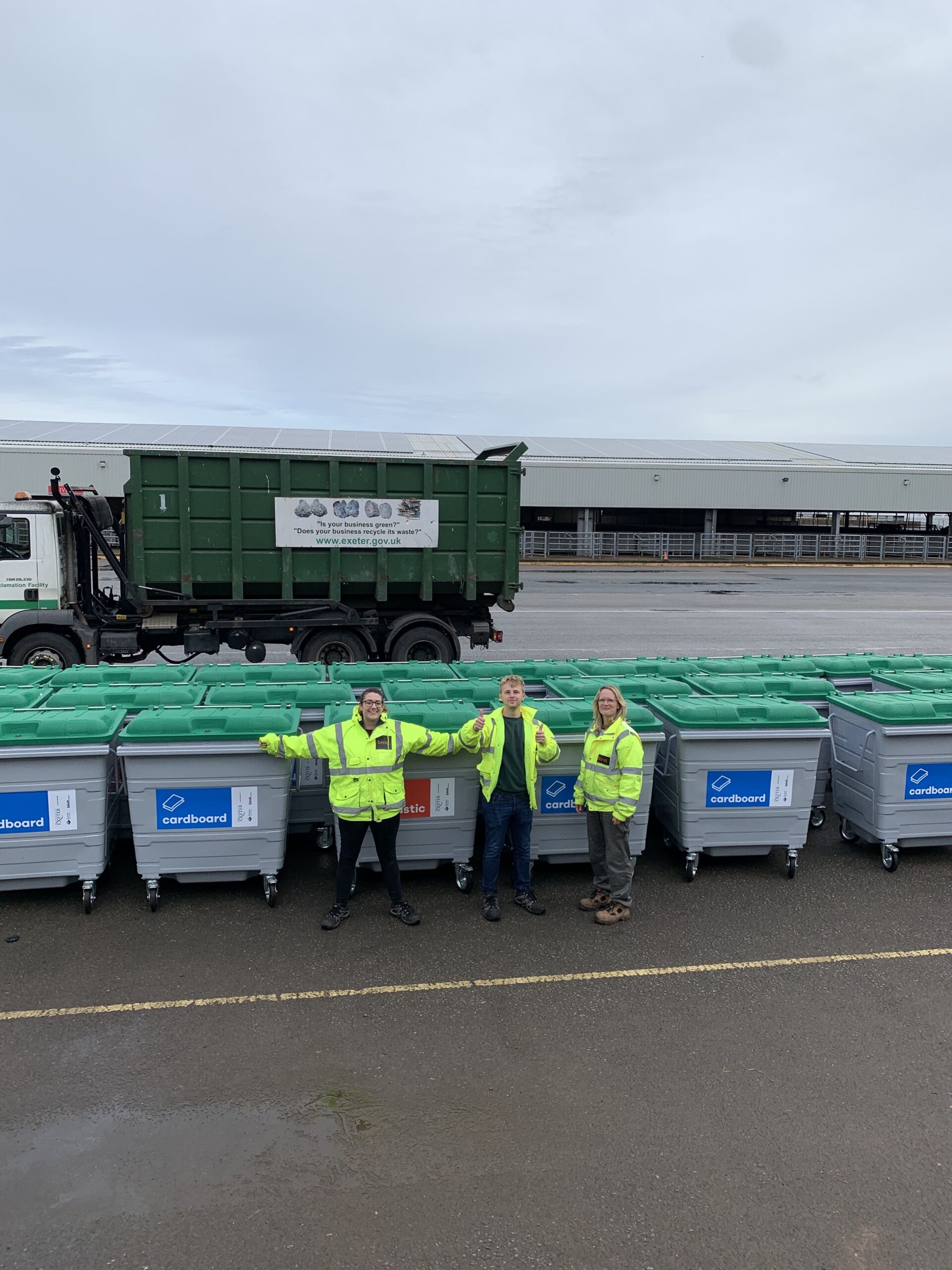 Binit team standing in front of large bins